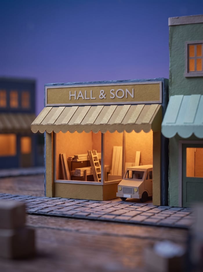 A model builder's merchant with a gold awning and a van at the kerb.