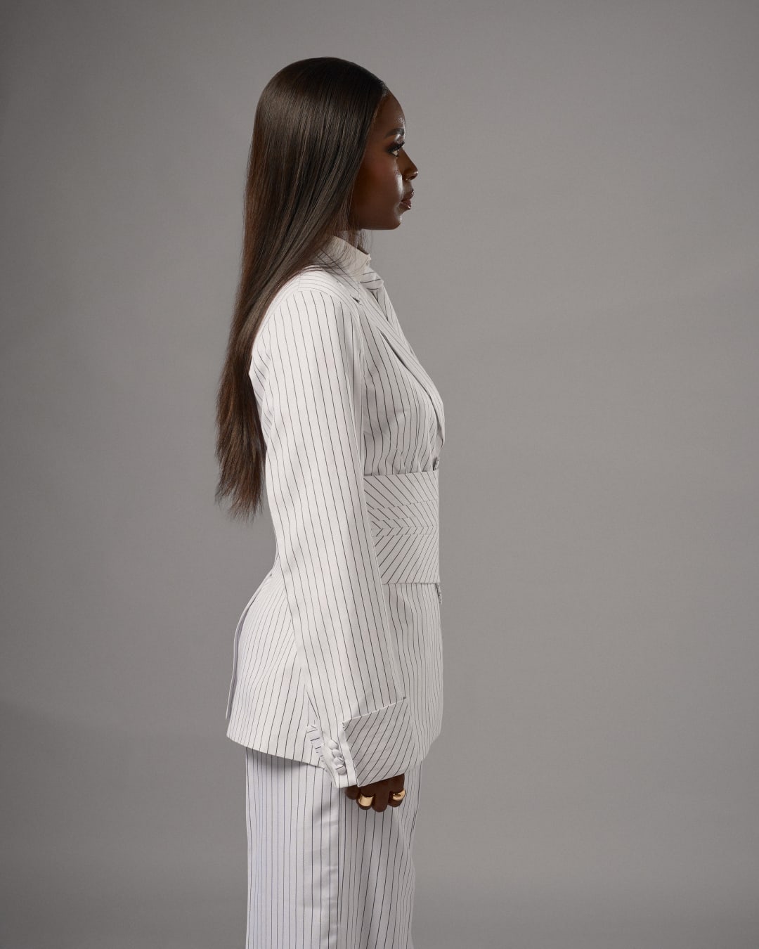 The white pinstripe suit in profile, arms straight down