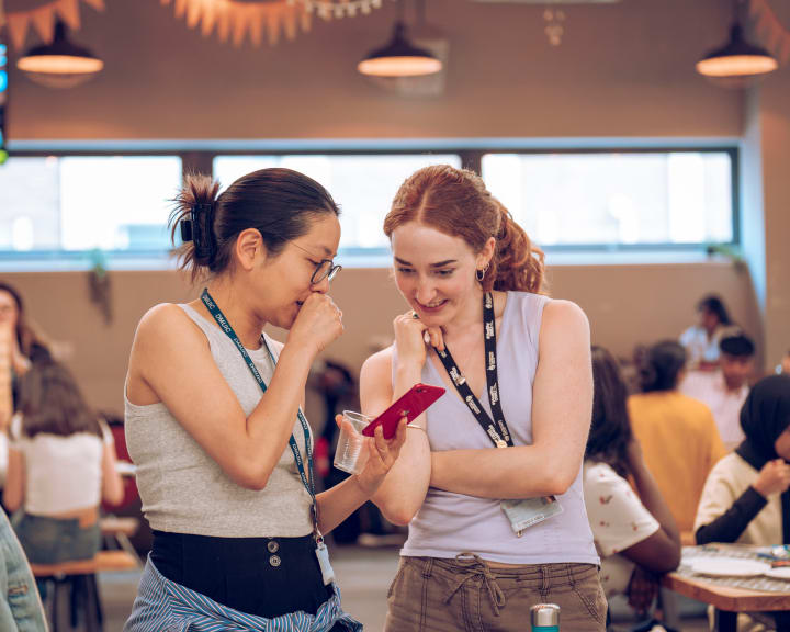 Two students laughing at a phone