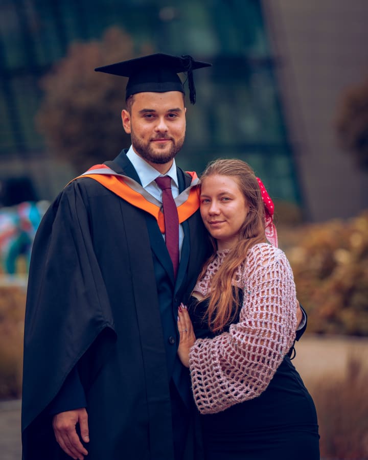 A graduate and her partner, cheek to cheek