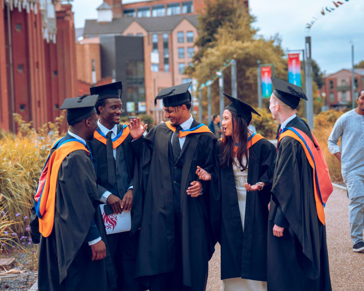 A line of graduates walking down the street