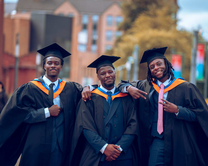 Four friends in gowns, laughing