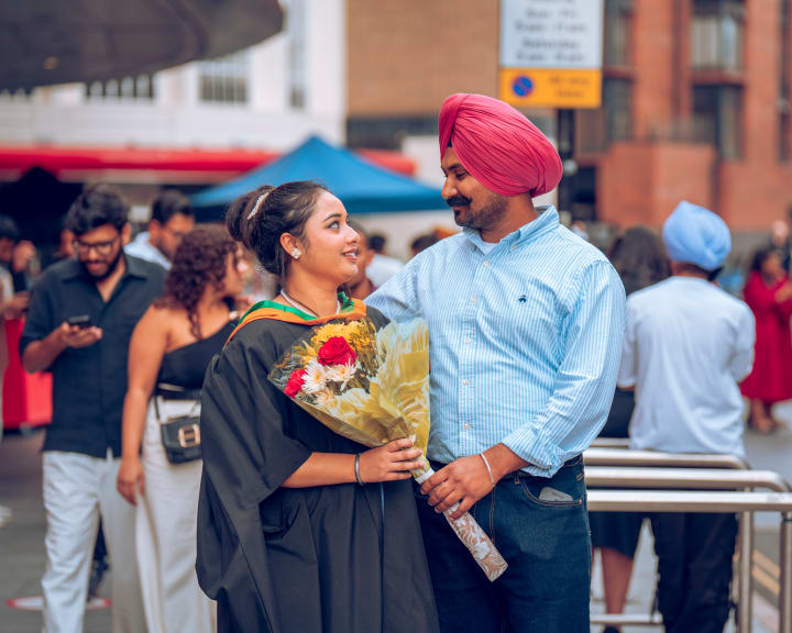 A father in a turban hugging his graduate