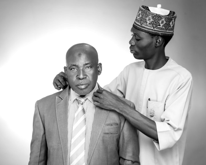 The tailor adjusting his collar, in black and white