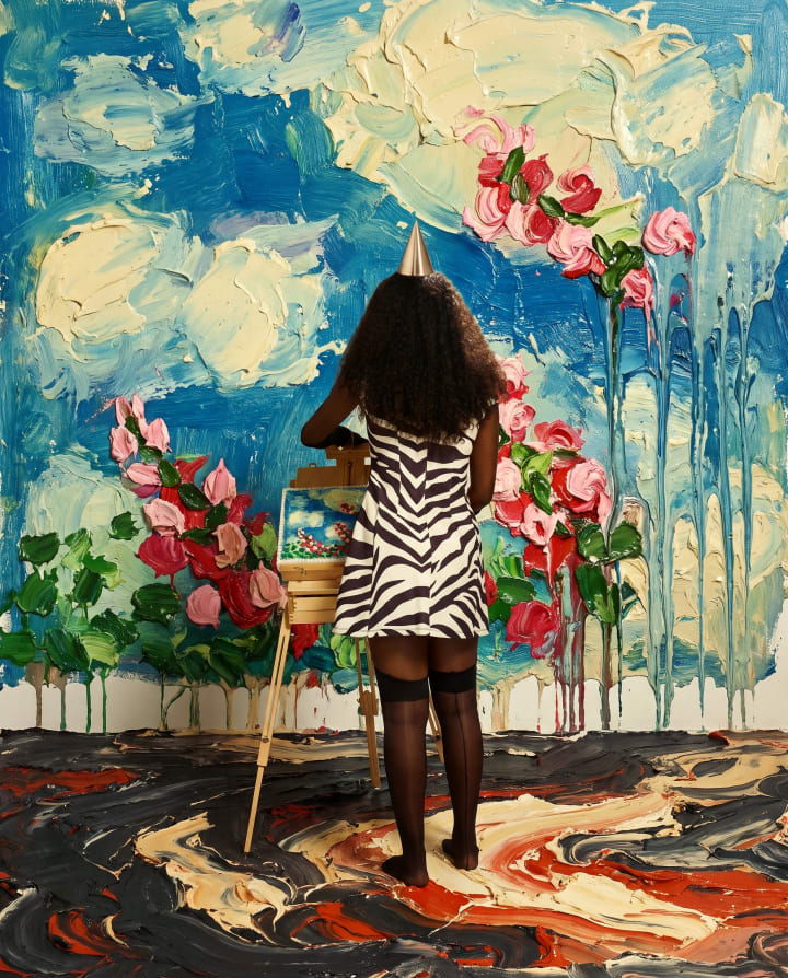 Ejiro from behind, painting roses onto a sky blue wall