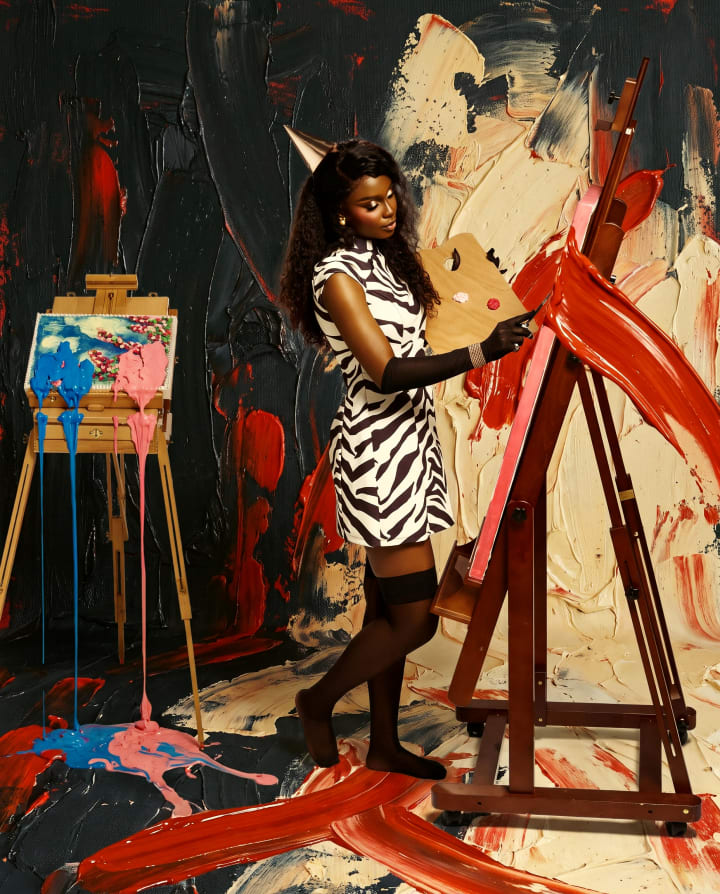 Ejiro at the easel, dragging a stroke of red paint across the canvas