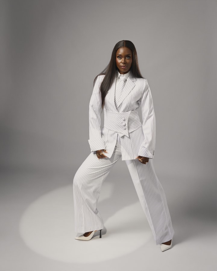 The white pinstripe suit, a wide stance in a pool of light