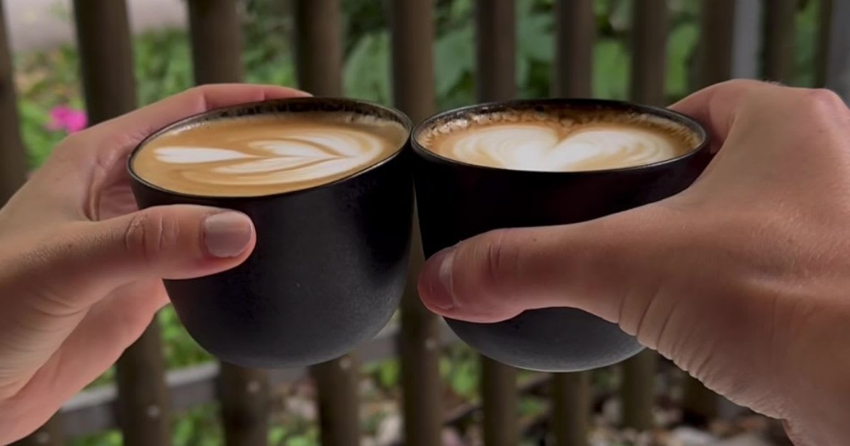 Toasting with two cups of coffee.