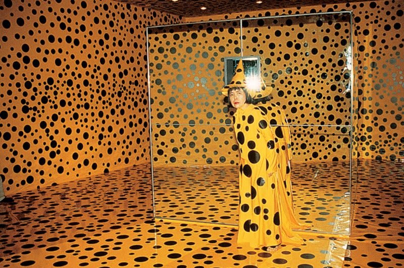 Peinture à l'huile de Yayoi Kusama représentant une citrouille géante aux nuances vives d'orange et de jaune, avec des détails minutieux.