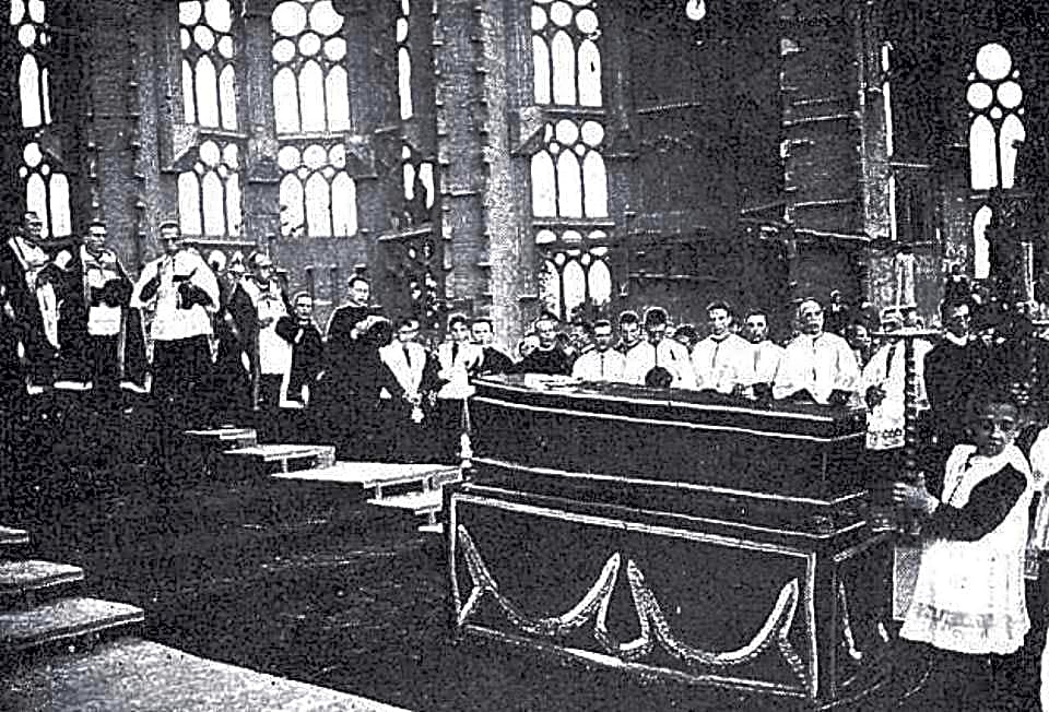 Arquiteto catalão Antoni Gaudí em frente ao Parque Güell, com detalhes ornamentais em tons de azul e amarelo, em Barcelona.