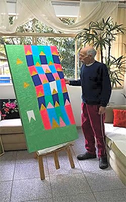 Retrato de Zi Facella, artista, com expressão serena e olhar direto, vestido com roupa clássica, em tons de cinza e azul.