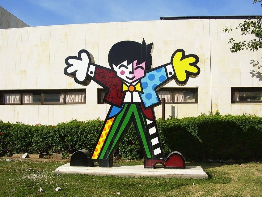 Escultura 'Boas Vindas' de Romero Britto, ubicada en el Jardín de Esculturas del Hospital Sheba en Israel, con formas coloridas y acogedoras.