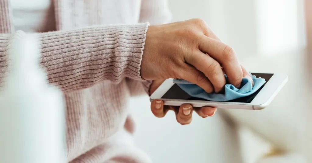 Limpiando teléfono con un paño