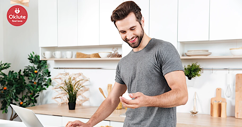 Imagen de hombre con barba utilizando notebook y sonriendo