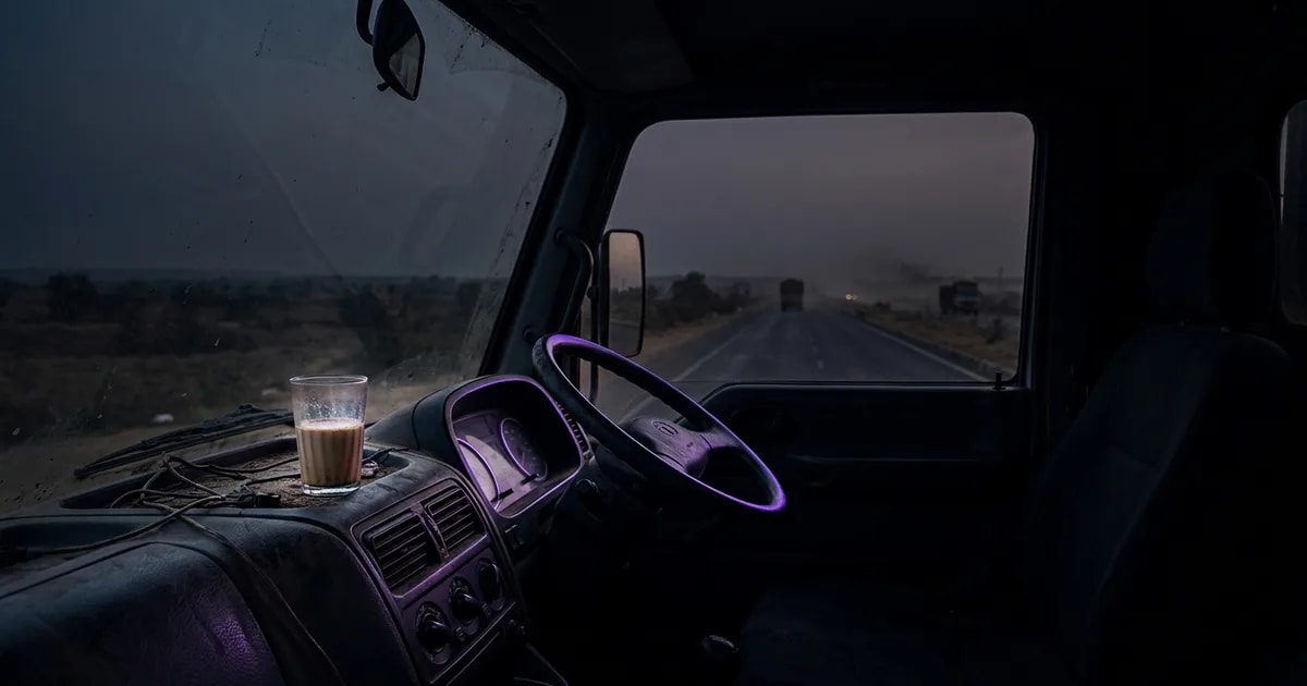 An AI dashcam view of a truck driver at night, with overlays showing fatigue detection for head position and eye closure.