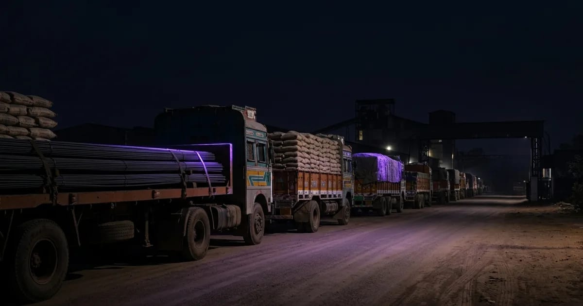A fleet of heavy trucks used for cement and steel transport lined up at an industrial site