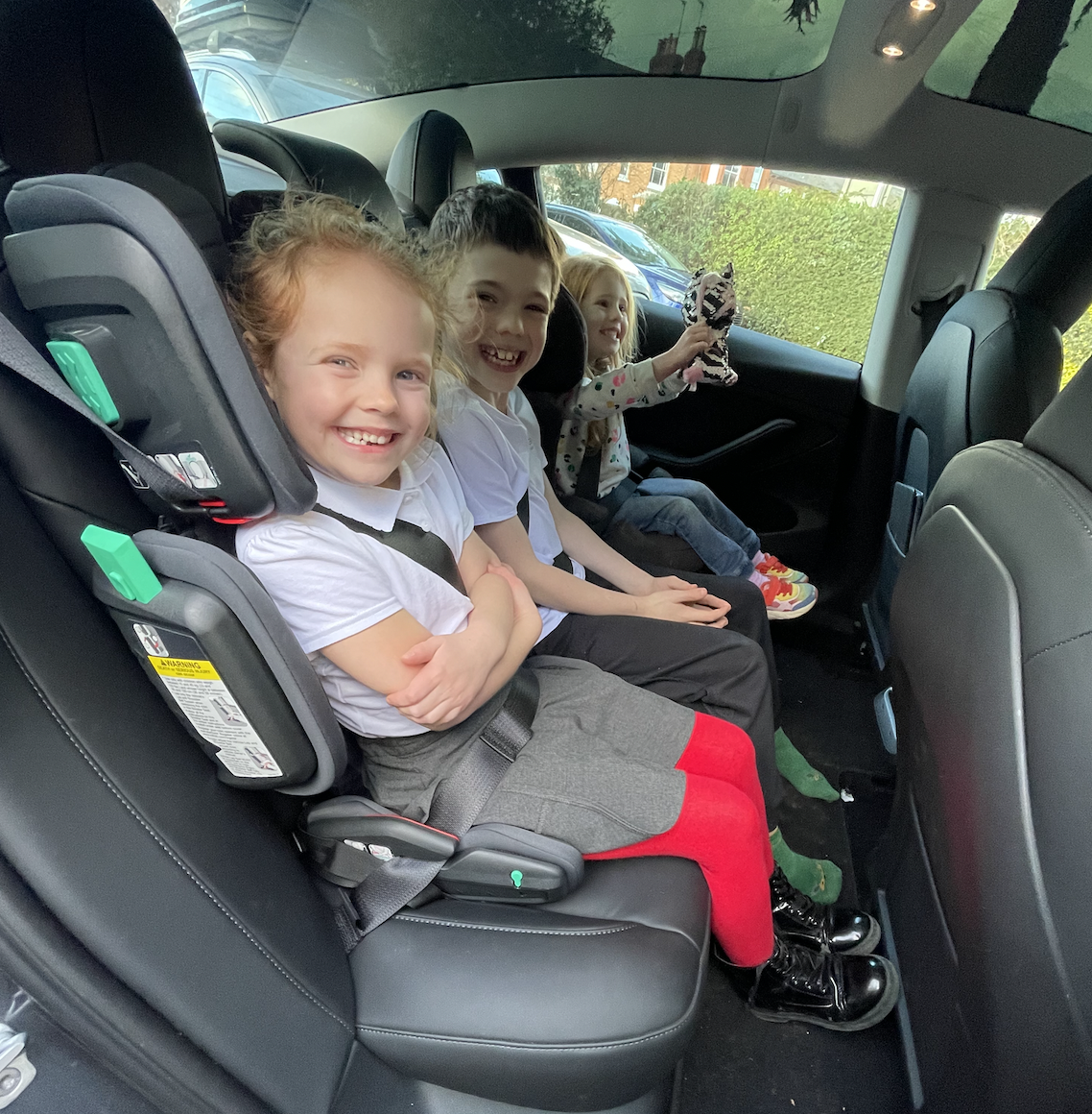 three kids sat across back seat