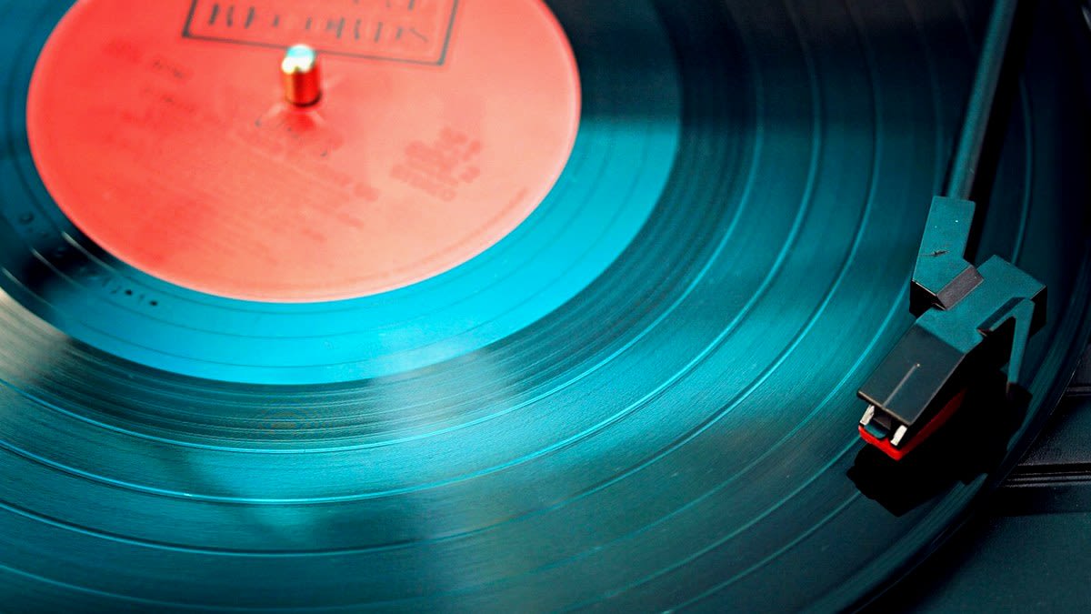 Editorial cover: teal vinyl on turntable with red label under cool cyan sidelight for Victoria Monet Frequency of Love.