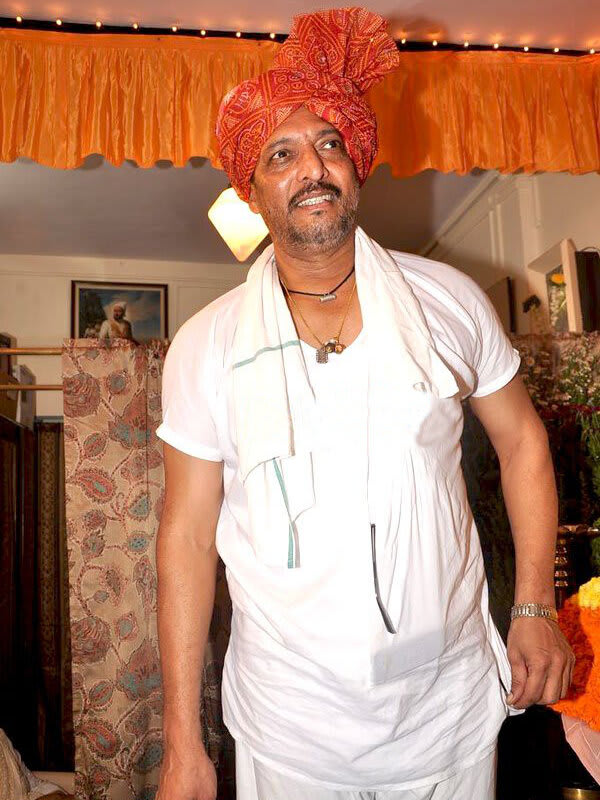 Nana Patekar in a white kurta and orange-red bandhani turban at a Ganesha darshan