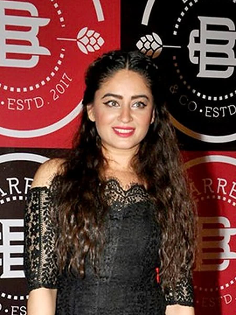 Television actor Mahhi Vij with long curly hair, smiling in a black lace dress at the Barrel & Co launch in Mumbai