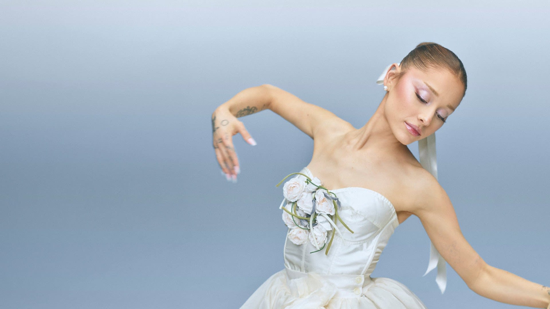 Ariana Grande in a white ballet tutu with rose appliqué and lilac-pink shimmer makeup in the r.e.m. beauty En Pointe holiday campaign