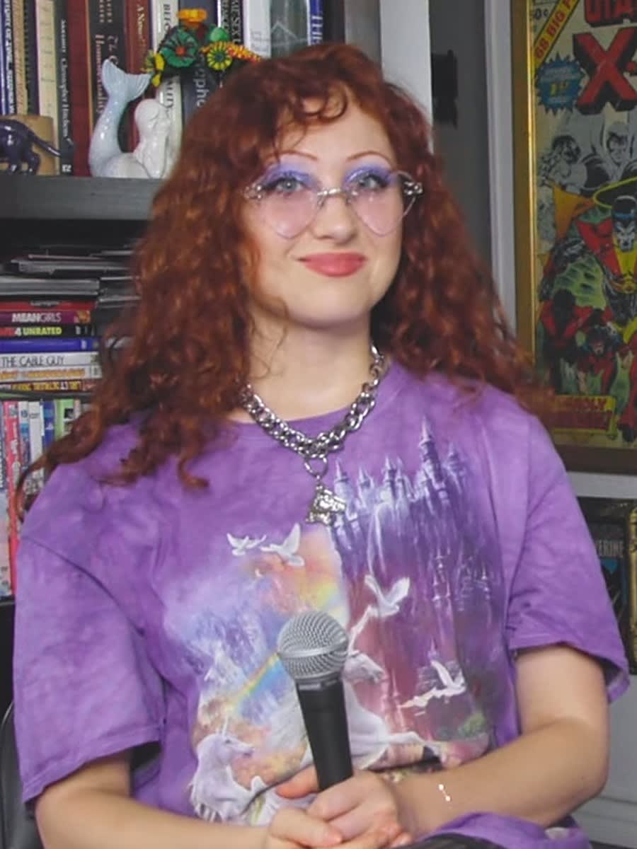 Chappell Roan with curly red hair and purple glasses in a lilac T-shirt during a 2023 Popdust interview