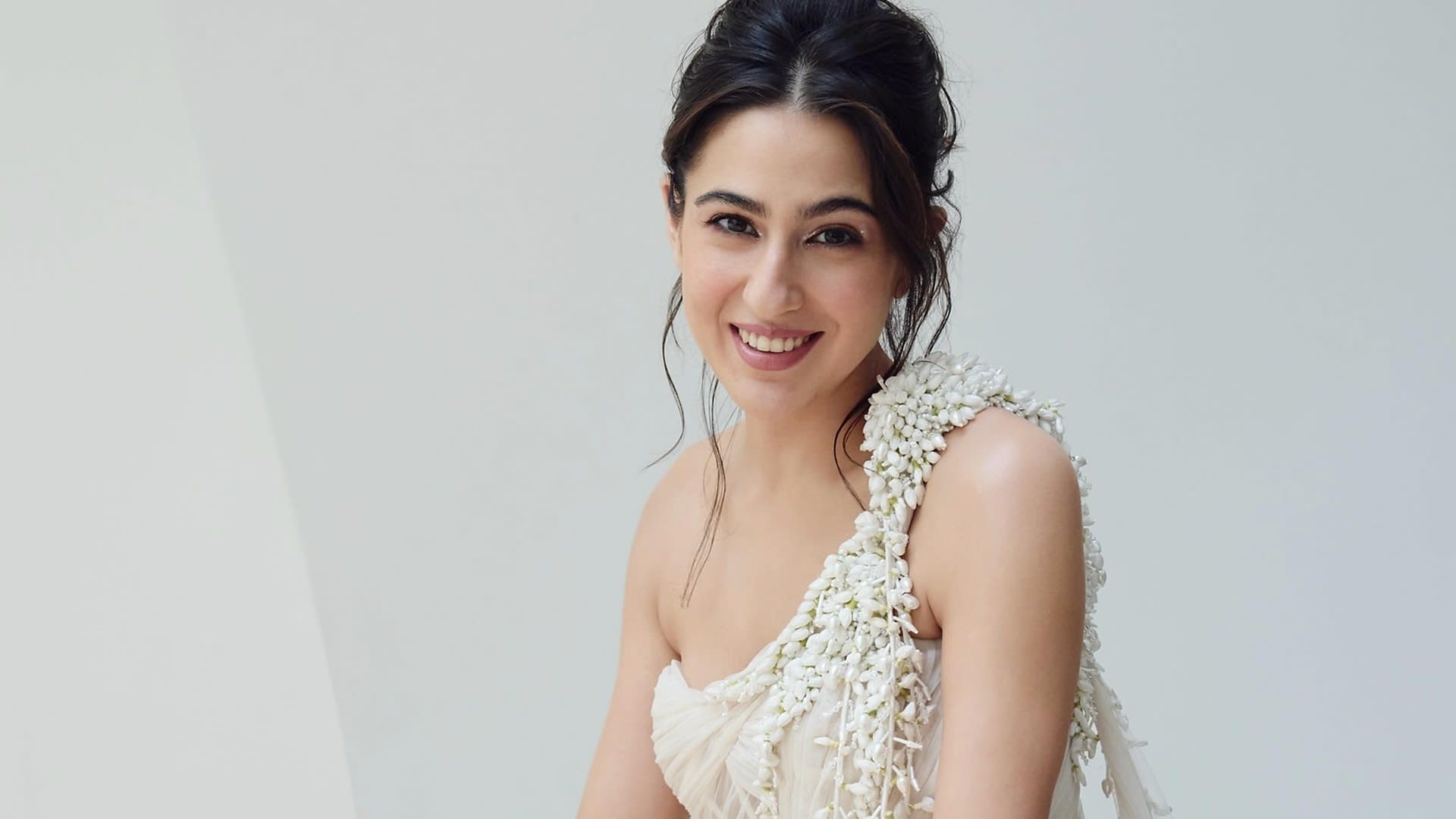 Sara Ali Khan smiling in Gaurav Gupta's ivory sculpted tulle saree-gown Emergence with hand-embroidered mogra tassels on the shoulder, The Bride Side campaign, October 2026