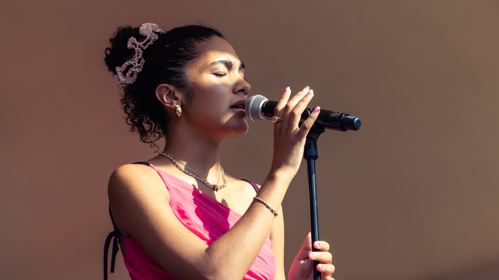 Olivia Dean singing on stage, 2023