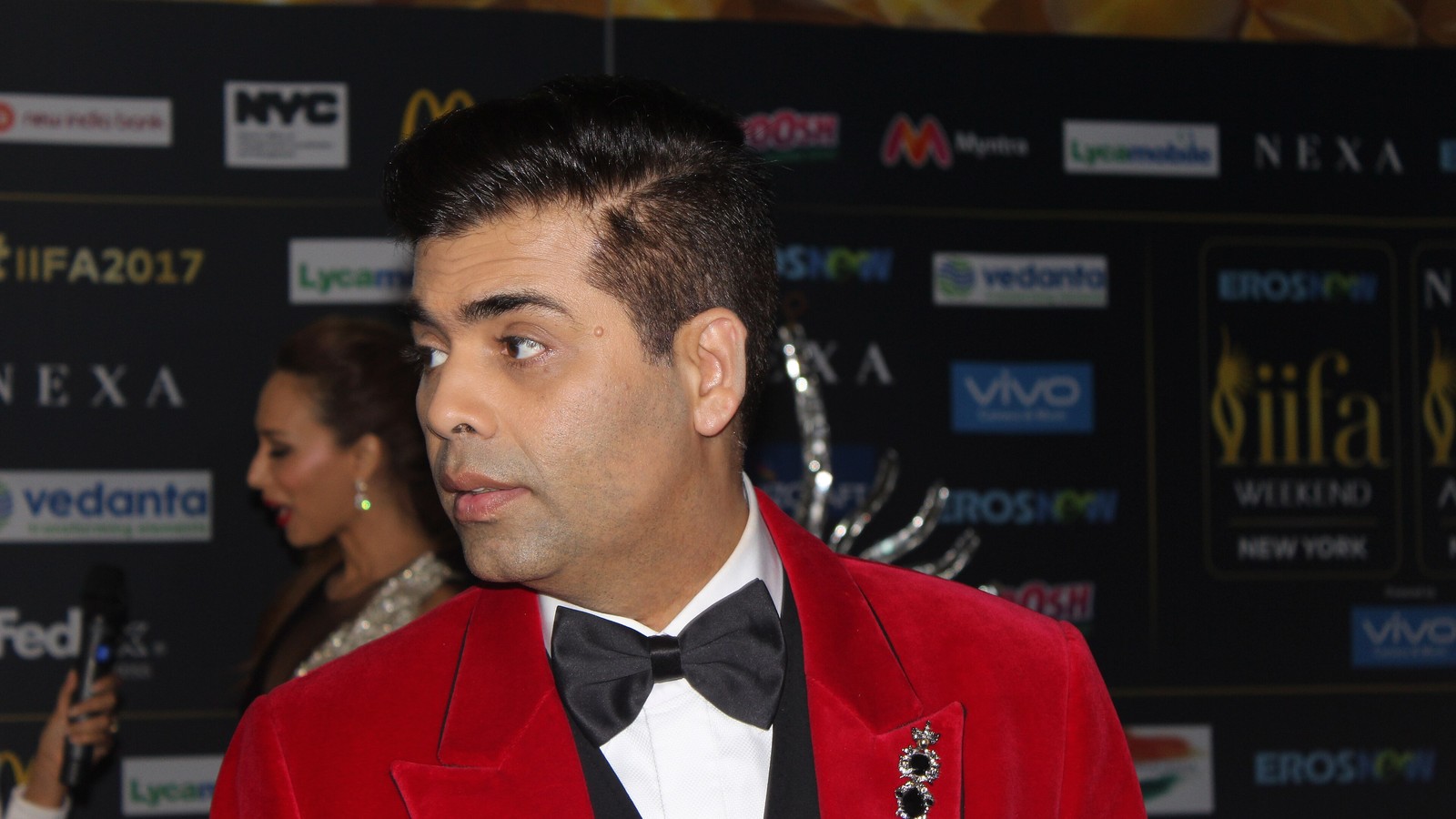 Filmmaker Karan Johar in a red jacket at an event