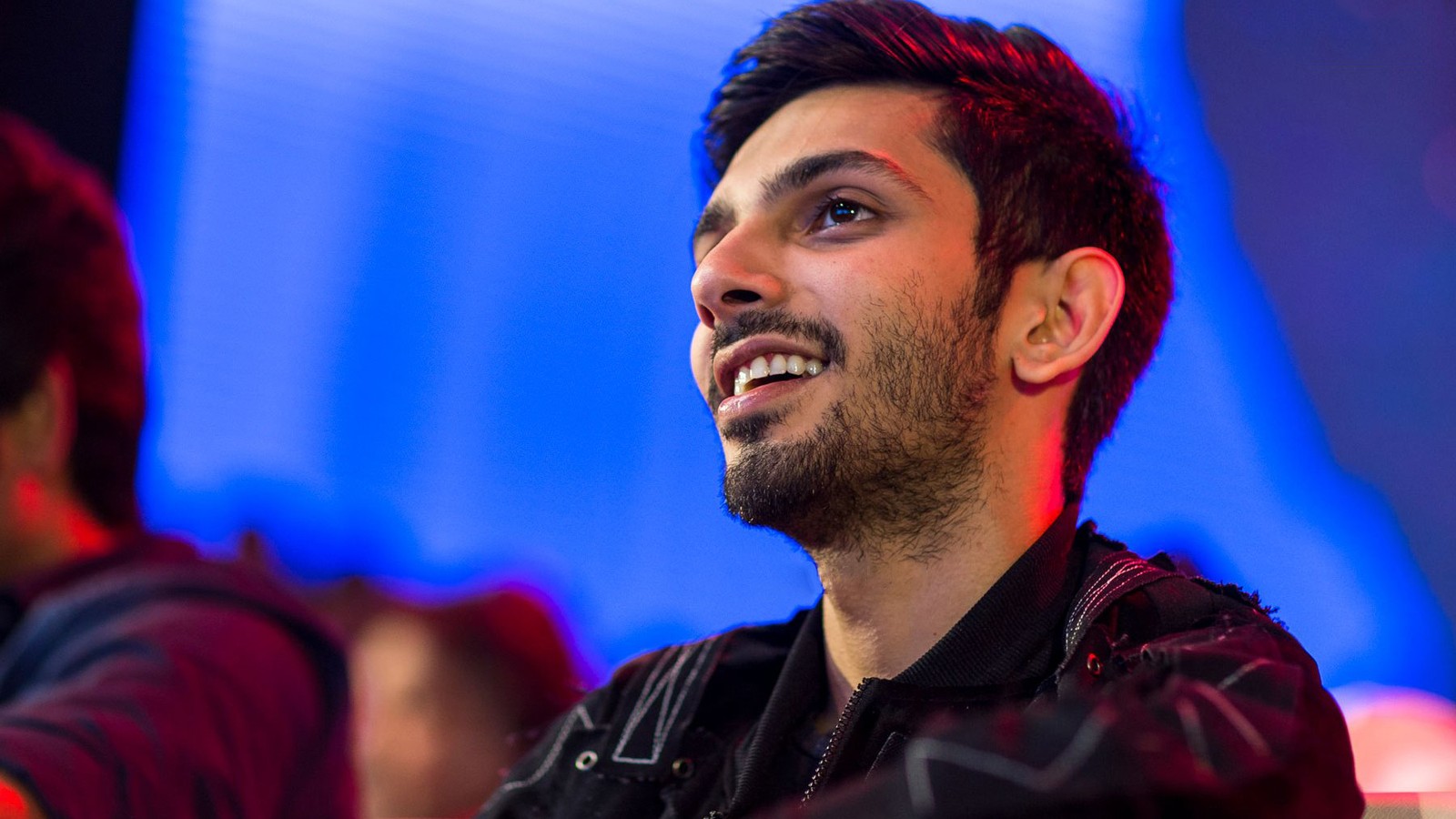 Composer Anirudh Ravichander smiling on stage at an audio launch
