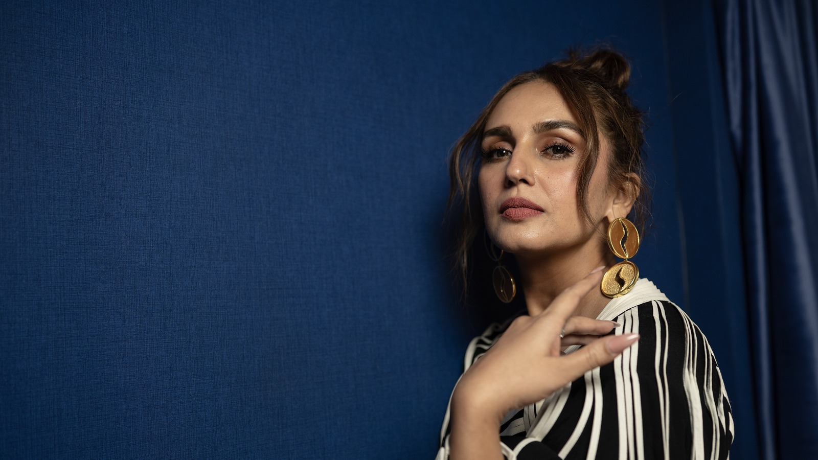 Actress Huma Qureshi in a striped dress and large earrings at TIFF 2025