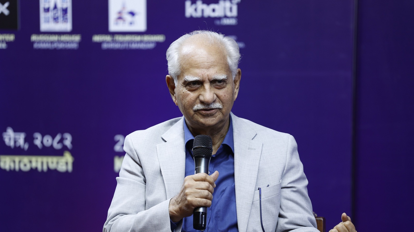 Director Ramesh Sippy in a grey blazer holding a microphone at a festival session