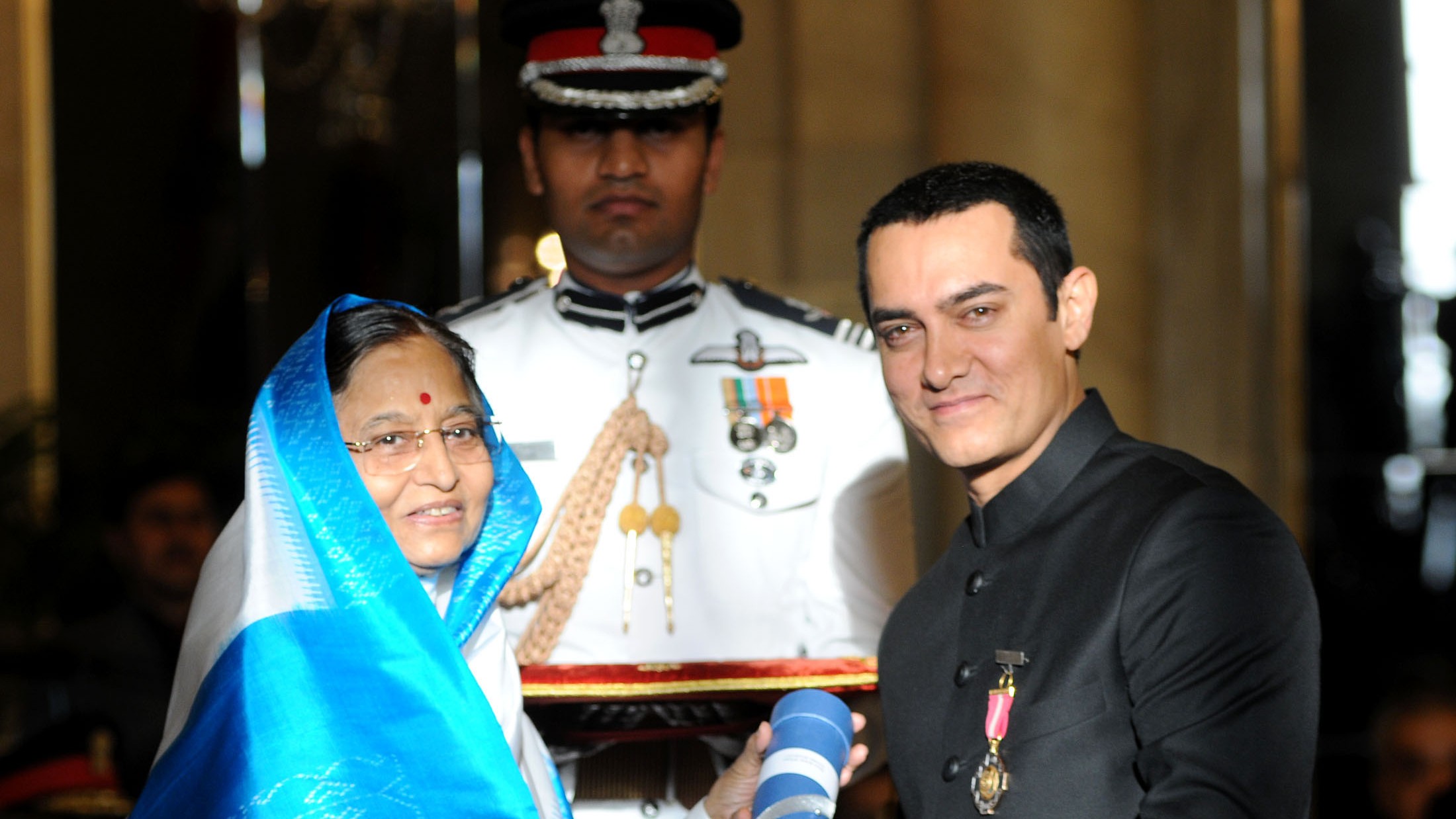 Aamir Khan in a black bandhgala receiving the Padma Bhushan from President Pratibha Patil at Rashtrapati Bhavan in 2010