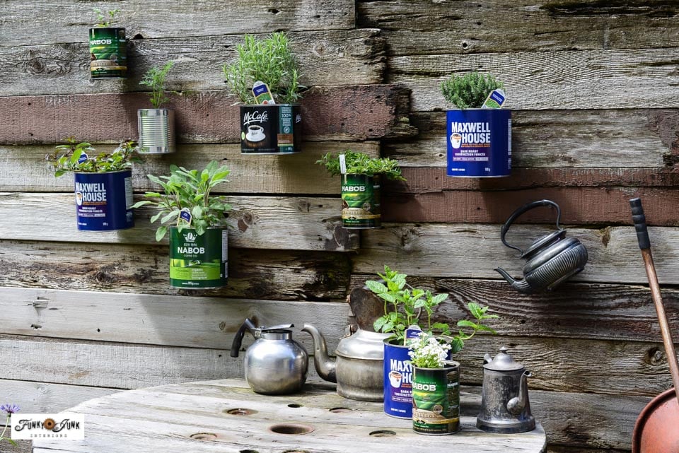 colorful painted tin cans with herbs on shelf