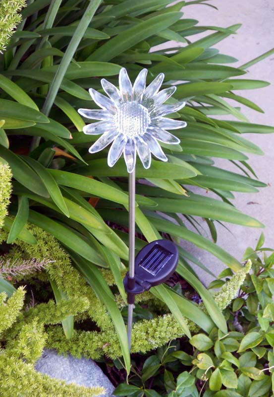 solar stake lights with flower tops in flower bed