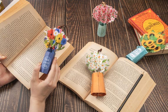 flatlay pressed flower resin bookmark on open book