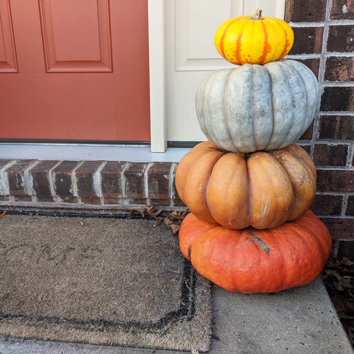 stacked orange pumpkins on porch steps