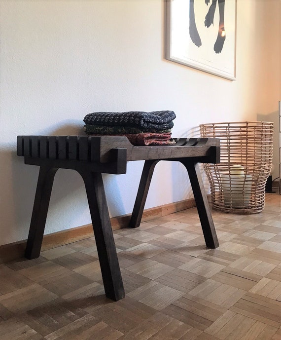 wooden bench with folded blankets on porch