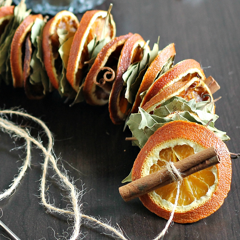 dried orange garland with pinecones mantel
