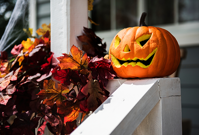 glowing jack o lanterns on halloween porch railing