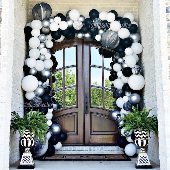 black and white balloon arch over doorway