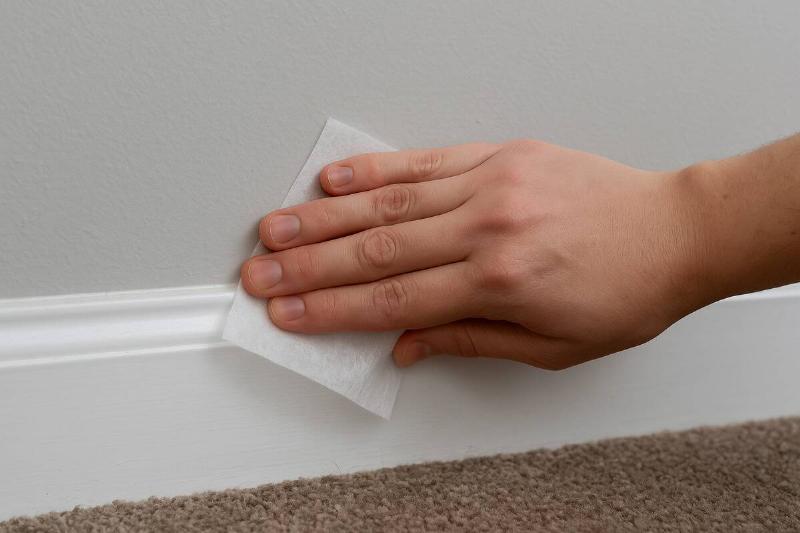 dryer sheet along white baseboard