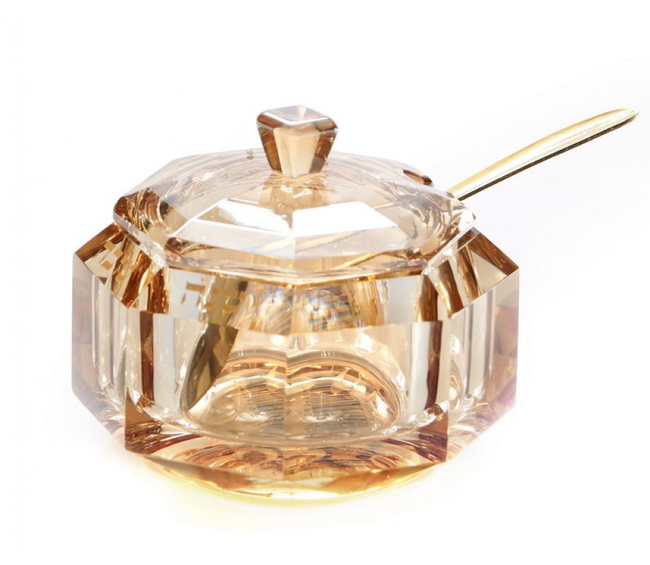 glass jar of amber honey with spoon