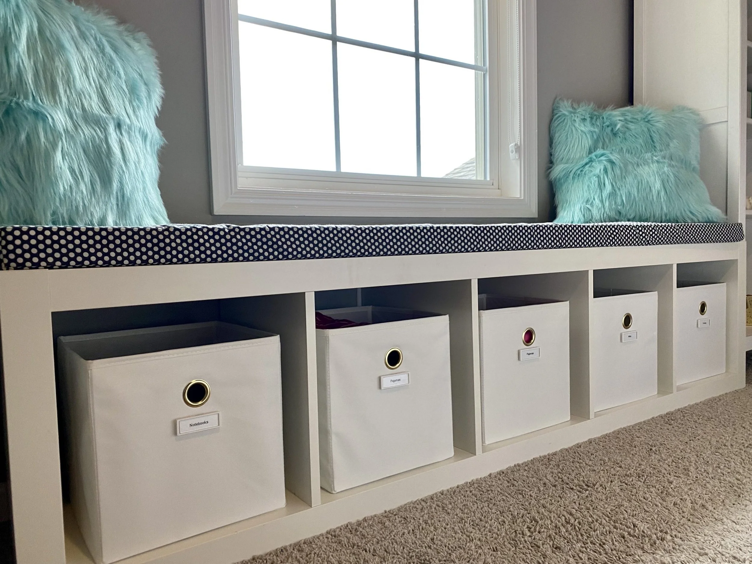 throw pillows inside labeled plastic bins