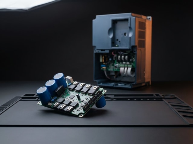 VFD invertor təmiri — arxada tezlik çeviricisi, önündə IGBT modulu və DC bus kondensatorları