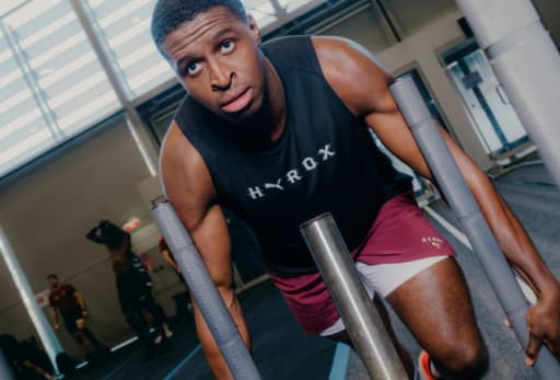 Ein Mann schiebt einen Schlitten in Puma Hyrox Trainingskleidung.