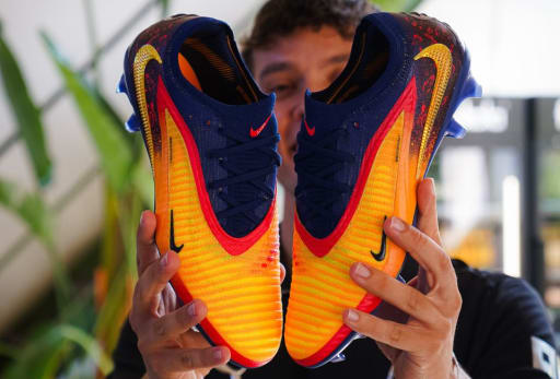Nike Haaland Phantom 6 Fussballschuhe werden in die Kamera gehalten.