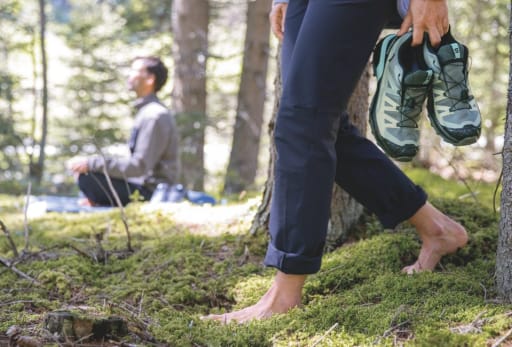 Ein Mann und eine Frau tragen herbstliche Outdoorkleidung von Jack Wolfskin und laufen auf einem Berg.