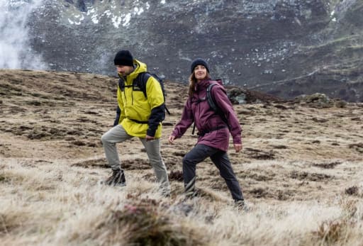 Mann und Frau wandern auf einem Berg.