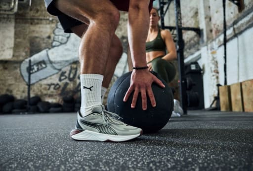 Ein Mann hebt einen Medizinball auf.